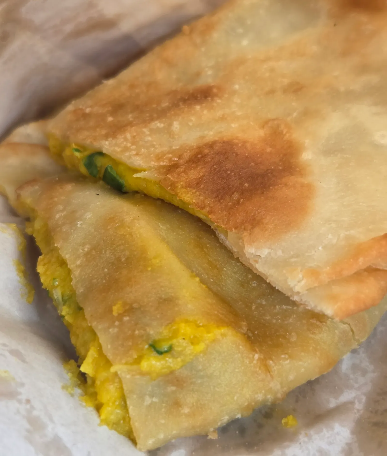 Bolani Afghan flatbread cut in half showing golden crust and potato herb filling
